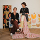 Portrait of Véronique de Soultrait and Michal Silver, Creative Director of Christopher Farr Cloth, seated with Véronique’s original artwork and a quilt draped over an upholstered chair in Galaxie fabric.
